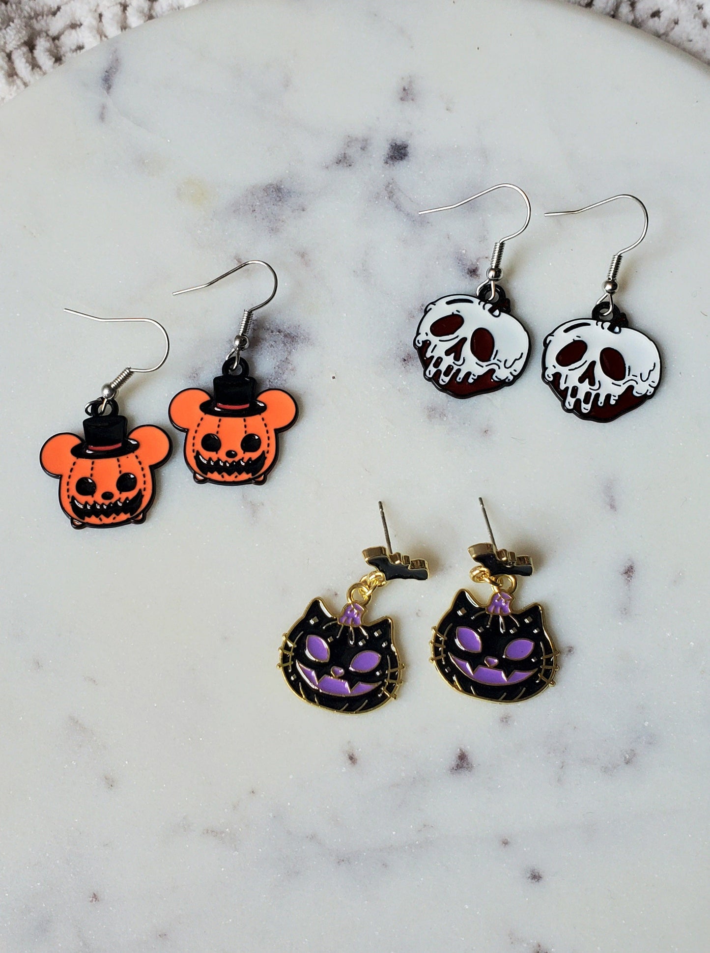 Set of Halloween-themed earrings on a marble surface