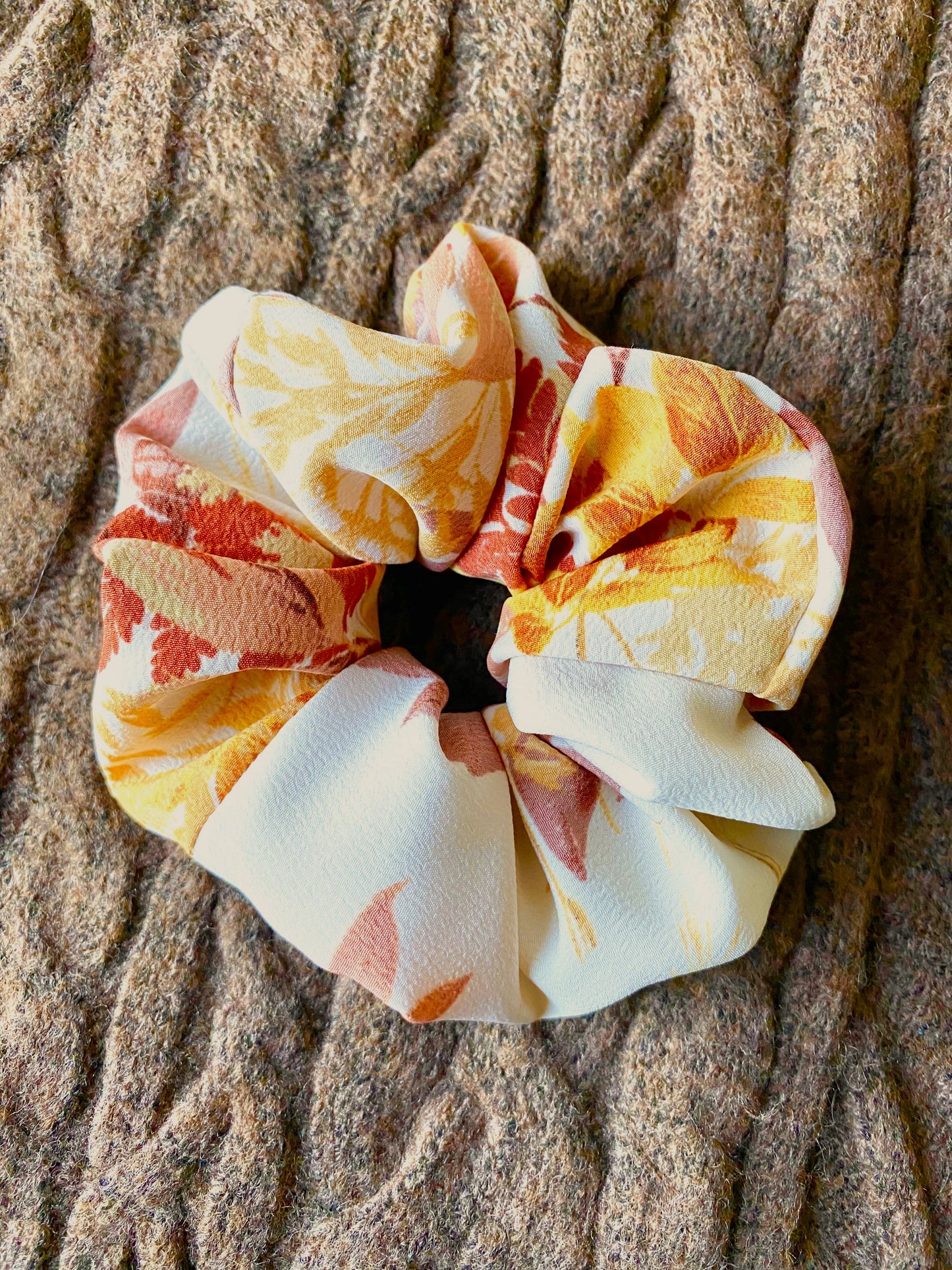 Orange, gold, red leaves displayed on this medium sized scrunchie.