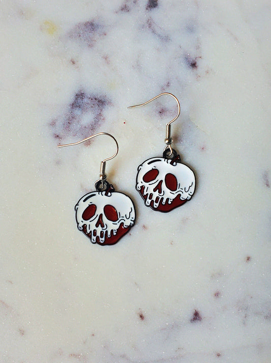 Skull-shaped earrings on a marble surface