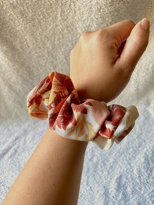 Orange, gold, red leaves displayed on this medium sized scrunchie.